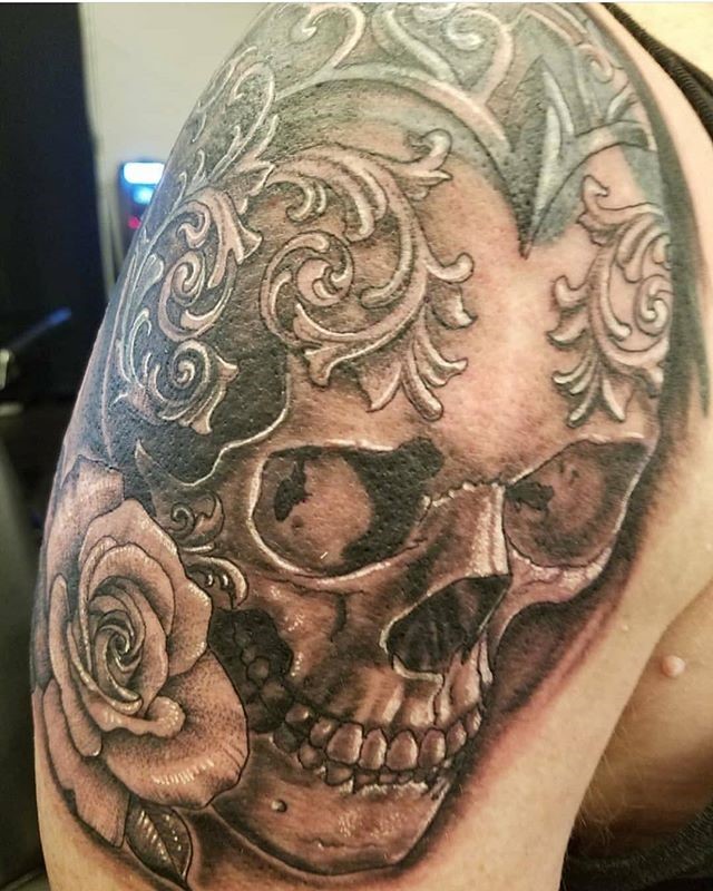 Black and Grey Skull Tattoo with Flowers and Embellishment by Tattoo Artist John Campbell created in Durham's Only Premium Custom Tattoo Parlor and Art Gallery - Sacred Mandala Studio